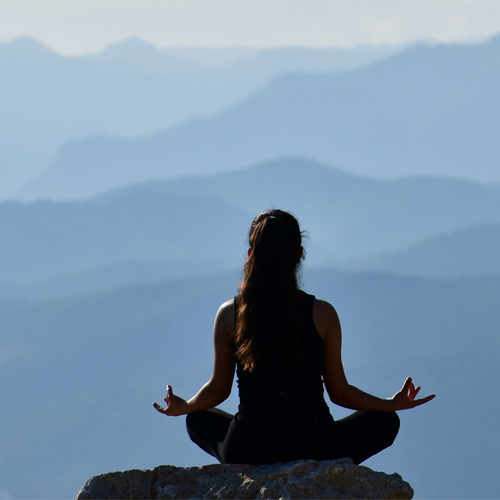 Young lady sitting with crossed legs and hands on knees upturned to the sky. Meant to illustrate the idea of immersion in Christ. Specifically in Proverbs 2