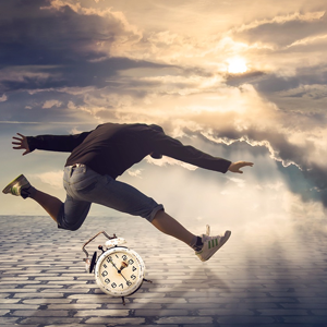 Man jumping over a clock. Meant to illustrate using time wisely.