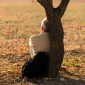 Older man sitting against a tree. Meant to illustrate who does God say I am?