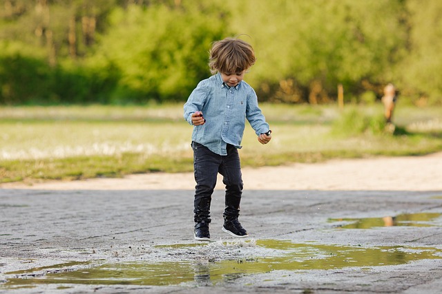 Young boy jumping in a water puddle. Meant to illustrate dancing in the Lord. Finding joy in God. 